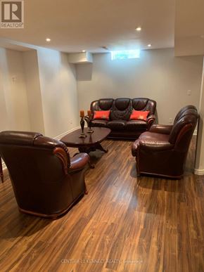 Vaughan (Crestwood-Springfarm-Yorkhill) apartment for rent - A brown leather couch and chair in a room with wooden flooring.