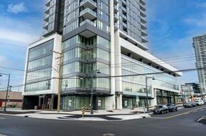 Surrey apartment for rent - A modern multi-story building with a glass facade and a sign that reads "GRAND".