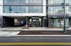 Surrey apartment for rent - The Grand On King George is a large building with a glass facade.