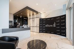Surrey apartment for rent - A black and white image of a lobby with a reception desk and a wall with the word "allure" on it.