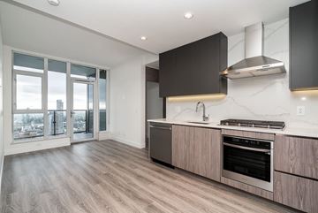 Surrey apartment for rent - A modern kitchen with a stainless steel oven and wooden cabinets.