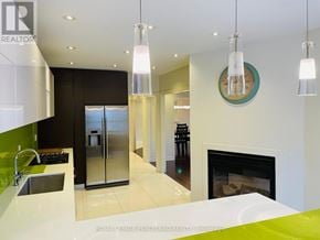 Richmond Hill (Westbrook) apartment for rent - A modern kitchen with a stainless steel refrigerator and a fireplace.