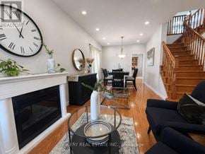 Kitchener apartment for rent - A living room with a fireplace and a large clock on the wall.