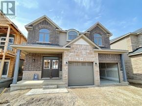 Brantford apartment for rent - A house with a grey garage door is for sale.