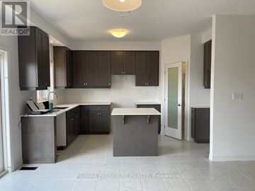 Brantford apartment for rent - A kitchen with dark brown cabinets and a white island.