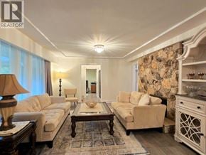 West Vancouver apartment for rent - A well-lit living room with a large sofa, a coffee table, and a side table with a lamp.