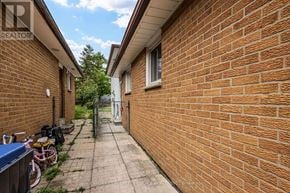 Mississauga (Malton) apartment for rent - A brick wall with a bicycle and a blue container on the left.