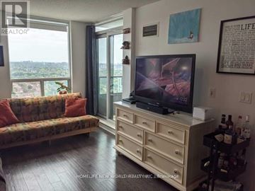 Toronto (Bendale) condo for rent - A living room with a couch, a television, and a window overlooking a cityscape.