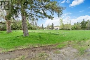 Edwardsburgh/Cardinal multi-family for rent - A grassy field with trees and a clear sky.