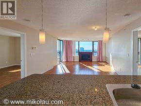 Burnaby apartment for rent - A spacious living room with a fireplace and large windows.