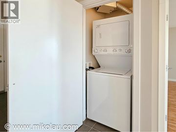 Burnaby apartment for rent - A white dishwasher is in a kitchen with a white wall.