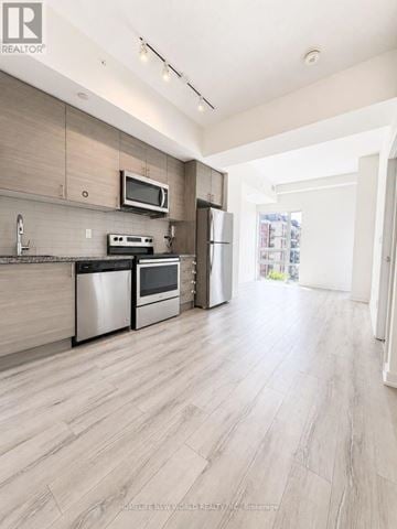 Toronto (Bayview Village) condo for rent - A modern kitchen with wooden cabinets and stainless steel appliances.