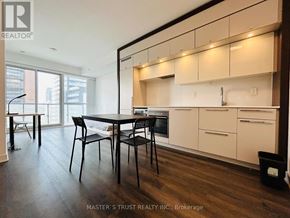 Toronto (Bay Street Corridor) condo for rent - A kitchen with white cabinets and a black table.