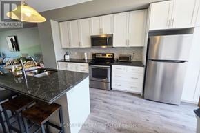 Hamilton townhouse for rent - A kitchen with a granite countertop and stainless steel appliances.