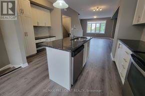Hamilton townhouse for rent - A modern kitchen with white cabinets and a central island.