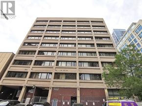 Toronto (Church-Yonge Corridor) condo for rent - A tall building with many windows and a Home Life New World REALTOR sign on the front.