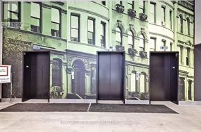 Markham (Unionville) condo for rent - Three black doors are in front of a mural of a green building.
