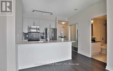 Mississauga (City Centre) condo for rent - A modern kitchen with white cabinets and appliances.
