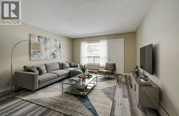 London apartment for rent - A living room with a grey sofa, a glass coffee table, and a television on the wall.