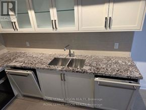 Toronto (Englemount-Lawrence) condo for rent - A kitchen with granite countertops and white cabinets.