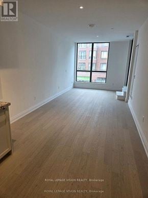 Toronto (Englemount-Lawrence) condo for rent - A spacious room with wooden flooring and a large window.