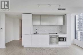 Toronto (Church-Yonge Corridor) condo for rent - A modern kitchen with white cabinets and appliances.