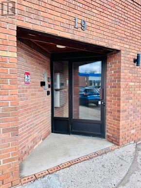 New Tecumseth (Alliston) multi-family for rent - A red brick building with a black door and a glass window.