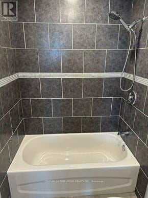 New Tecumseth (Alliston) multi-family for rent - A white bathtub in a bathroom with grey tiles.