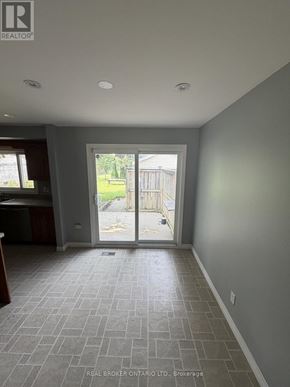 Haldimand apartment for rent - A room with grey tiled flooring and a sliding glass door leading to a backyard.