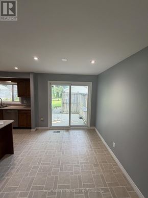 Haldimand apartment for rent - A spacious room with tile flooring and a sliding glass door leading to a balcony.
