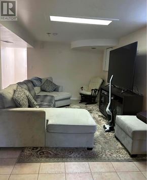 Mississauga (Fairview) apartment for rent - A living room with a couch, ottoman, and television.