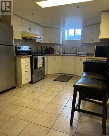 Mississauga (Fairview) apartment for rent - A kitchen with white cabinets and a black chair.