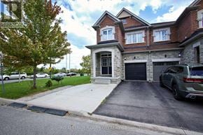 Brampton (Northwest Brampton) apartment for rent - A house with a garage and a tree in front of it.