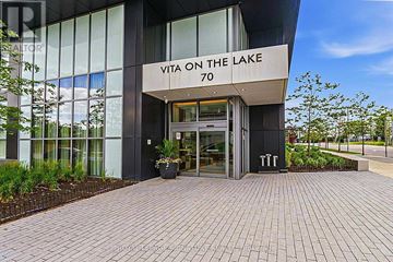Toronto (Mimico) condo for rent - A building with a glass facade and a sign that reads "VITA ON THE LAKE 70".
