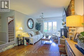 Grimsby (Grimsby West) apartment for rent - A well-lit living room with a couch, a coffee table, and a staircase.