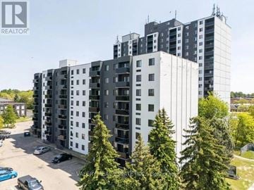 Kitchener multi-family for rent - A tall residential building with a parking lot in front.