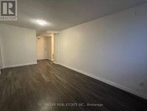 Kitchener multi-family for rent - A room with wooden flooring and white walls, part of a property managed by Valery Real Estate Inc.