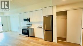 Brantford condo for rent - A kitchen with white cabinets and a stainless steel refrigerator.
