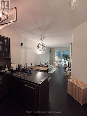 Toronto (Willowdale West) condo for rent - A kitchen with dark wood cabinets and a black floor.