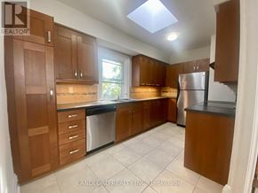Toronto (Casa Loma) multi-family for rent - A kitchen with brown cabinets and a refrigerator.