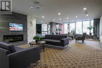 Toronto (Rouge) condo for rent - A living room with a fireplace and a television on the wall.