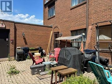 Toronto (Lambton Baby Point) multi-family for rent - A patio with a table and chairs is covered with a black tarp.