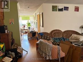 Toronto (Lambton Baby Point) multi-family for rent - A living room with a couch, a chair, and a pile of boxes on the floor.
