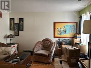 Toronto (Lambton Baby Point) multi-family for rent - A room with a brown chair and boxes on the floor.