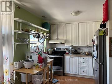 Toronto (Lambton Baby Point) multi-family for rent - A kitchen with white cabinets and a green wall.