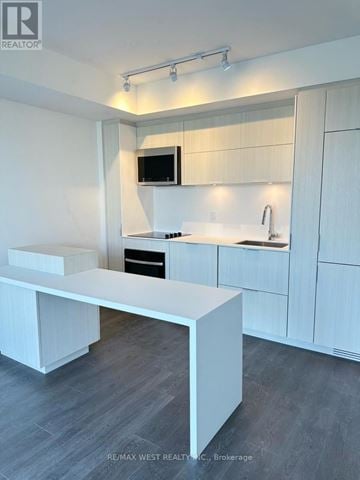 Burlington (Brant) condo for rent - A modern kitchen with white cabinets and a white island.