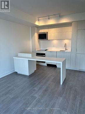 Burlington (Brant) condo for rent - A white kitchen with a table and a microwave above it.