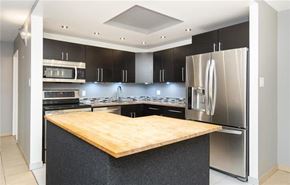 Winnipeg townhouse for rent - A modern kitchen with a wooden island and stainless steel appliances.