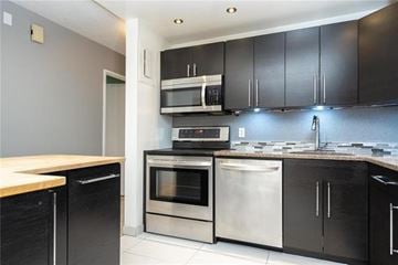 Winnipeg townhouse for rent - A kitchen with black cabinets and stainless steel appliances.