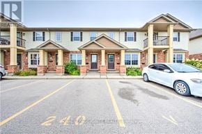 London South (South U) townhouse for rent - A white car is parked in a parking lot in front of a building.